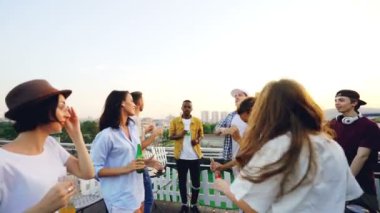 Profesyonel Dj karıştırma konsol ile çalışıyorken neşeli genç insanlar şişe çatı ve dans modern açık partide demir. Tatil ve yaz konsepti.