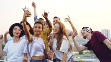 Selfie açık partide arkadaşlarıyla dans ve kamera için poz alarak çekici Afro-Amerikan kız ağır çekim. Eğlence, gençlik ve teknoloji kavramı.