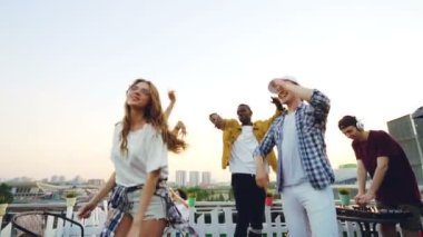 Dans ve açık hava partisinde profesyonel ekipman kullanarak Dj ile rahatlatıcı arkadaşlar çok etnik grubun ağır çekim. Güzel bir şehir arka planda görünür.