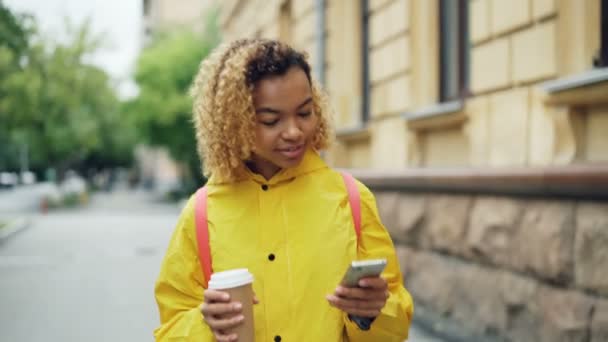 Sourire Fille Afro Américaine Utilise Smartphone Textos Amis Tenant Aller — Video