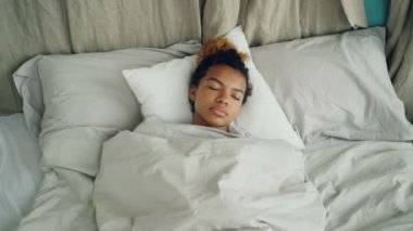 Geri kalan güzel keten sahip sıcak battaniye altında rahat yatakta uyuyan genç Afrikalı-Amerikalı kadın. Konfor, insanlar ve yatak odası konsept dinlenme.