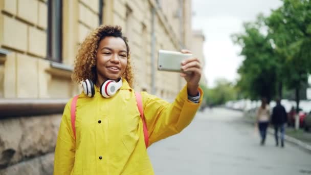 Joyeux mixte fille de race fait appel vidéo, parlant et riant tenant smartphone et regardant l'écran. Concept de technologie moderne, de communication et de jeunesse . — Video