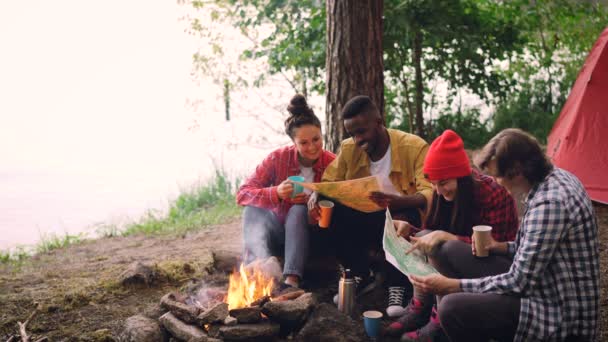 Цикл Кинематографа Счастливые Молодые Люди Смотрят Карты Сидящие Лесу Вокруг — стоковое видео
