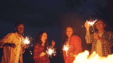 Yavaş hareket eğleniyor, dans ve açık havada maytap, yanan ile atlama kadın ve erkek tatil kutluyor ve iyi bir şirket zevk. İnsanlar ve eğlence kavramı.