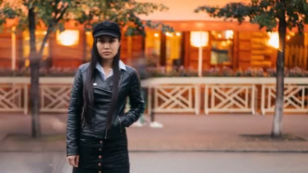 Time-lapse portrait of tired Asian girl standing in pedestrian street with hand in pocket and looking at camera then leaving, men and women are whizzing around. — Stock Video