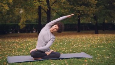 İnce kız beden ve Kol germe sonra eller kness ve kapalı gözler ile lotus pozisyonda rahatlatıcı sağlıklı omurga için yoga egzersizleri yapıyor. Gençlik ve meditasyon kavramı.