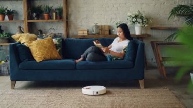 Robot elektrikli süpürge pretty Asya Bayan boş vaktinizi kitap okurken halı hareket modern loft tarzı Dublex ahşap zemini boya.