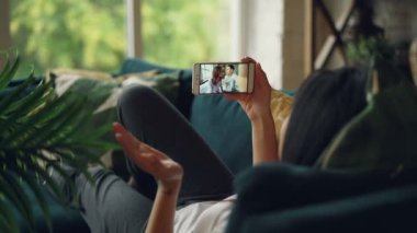 Kız öğrenci arkadaşlarıma güzel çift Çevrimiçi yapma görüntülü arama ekranına bakarak ve konuşmak smartphone ile konuşuyor. Konuşma ve teknoloji kavramı.