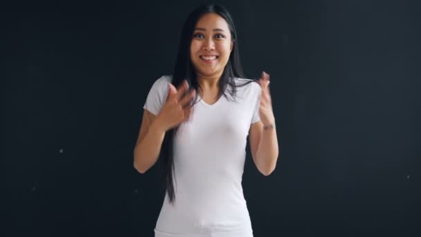 Retrato de bela menina asiática sorrindo e rindo expressando surpresa, felicidade e emoções positivas pulando e acenando as mãos. Boas notícias e conceito de pessoas . — Vídeo de Stock
