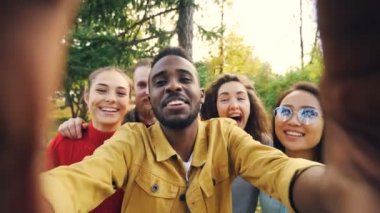 Bakış açısı shot selfie alarak arkadaş kameraya bakarak, komik surat ve gülüyor eğleniyor park. Modern teknoloji, dostluk ve doğa kavramı.
