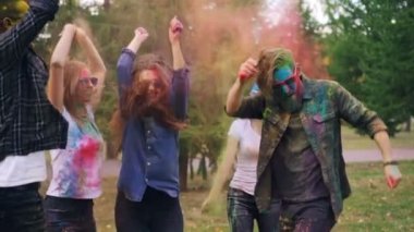 Yavaş moton neşeli erkek ve kadınların atlama, gülen ve Park'ın bahçesinde renkli toz atma Holi renkleri Festivali zevk. Gençlik Kültür ve etkinlik kavramı.