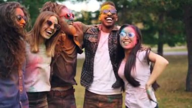 Ağır çekim mutlu oynak insanların birbirlerinin bir arada tutan atlama, gülen ve having fun renkli yüzleri ve giyim ile omuzlar. Arkadaşlık ve eğlence kavramı.