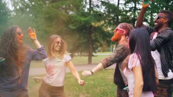 Radosny dziewczyny i chłopaki są zabawy na imprezie taniec z pomalowanymi twarzami i śmiejąc się na świeżym powietrzu w parku, ciesząc się wypoczynek i wakacje. Koncepcja młodzieży i uroczystości. — Wideo stockowe