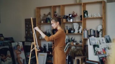 Küçük hanım yaratıcı hobi zevk modern studio çalışma resim üzerinde odaklanmıştır. Otantik sanat, sanat araçları ve ekipmanları arka planda vardır.