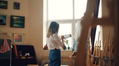 Profesyonel ressam genç bayan deniz manzara gemi ve deniz dalgaları rahat çalışma studio tasvir akrilik boya ile resim deniz manzarası var. İnsanlar ve iş kavramı.