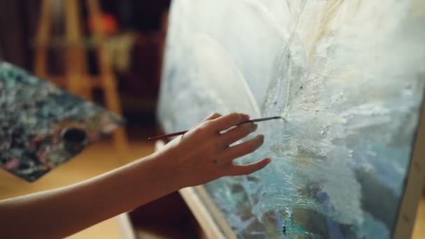 パレットにオイル塗料を使用の傑作を作成美しい絵を描いて女性アーティストのクローズ アップ ショットは、職業に集中しました。功妙な仕事および青年のコンセプト. — ストック動画