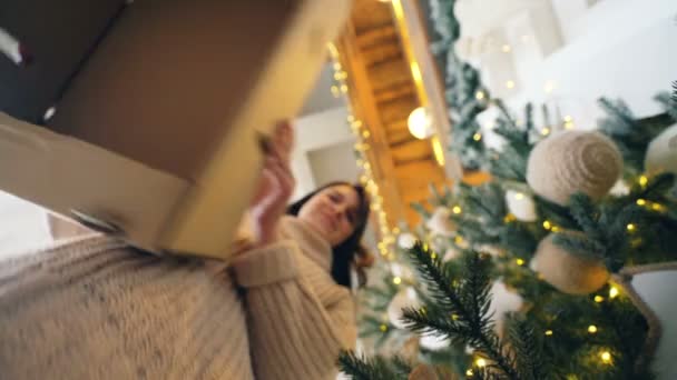 Szczęśliwa młoda kobieta otwiera pole obecne, klaskanie rękami i wyrażania pozytywnych emocji, następnie biorąc pudełko i ogarnięcie go. Koncepcja niespodzianka i Boże Narodzenie. — Wideo stockowe