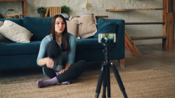 Mulher atraente vlogger está usando a câmera do smartphone para gravar vídeo sobre óculos de realidade virtual. Menina está segurando dispositivo, mostrando-o para assinantes e falando . — Vídeo de Stock