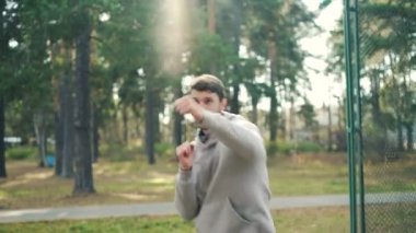 Profesyonel sporcu mücadele hareketleri yalnız eşofman giyen iyileştirilmesi silah taşıma parkta yalnız boks. Doğa kavramı, aktif Gençlik ve spor.