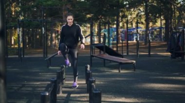 İnce kız açık havada spor-park eğitim yalnız toprağa üzerinde metal çubukları üzerinde adım aerobik spor yapıyor. Aktif gençlik, eğlence etkinliği ve insanlar kavramı.