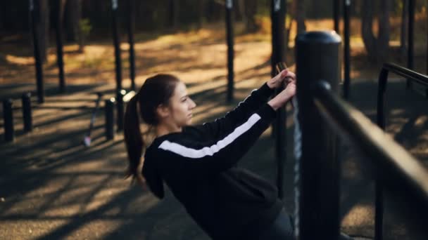 フィットの若い女性は運動屋外秋の朝は一人で訓練の場で低鉄棒で懸垂をしています。アクティブなライフ スタイルとスポーツ コンセプト. — ストック動画