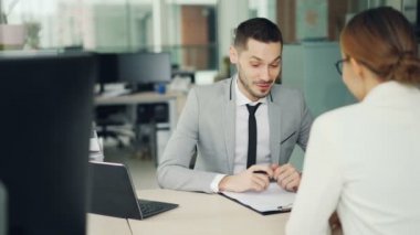 Neşeli adam görüşmeci gülümseyen ve soru sorma kadın adayı için modern ofis, masada oturmuş boş konuşuyor. İnsan kaynakları ve konuşmaları kavramı.