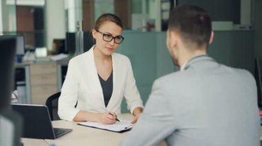 Güzel kadın işveren iş görüşmeci Office sırasında erkek aday konuşuyor, kız not alma sonra elini sallayarak ve gülüyor. Başarı ve iş yeri kavramı.