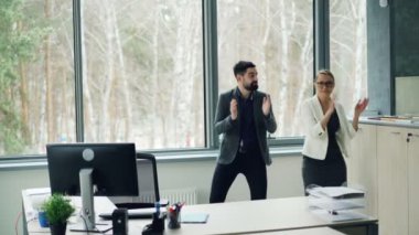 Yakışıklı genç insanlar iş arkadaşlarınızla ofiste dans ve müzik ve dinlenme zevk eller alkışlar. Gençlik yaşam tarzı, iş ve parti konsept.