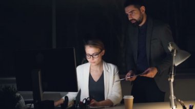 Şirket CEO'su sekreteriyle bilgisayarla çalışma emirleri ve iş tartışırken geç saatleri konuşuyor. İnsanlar resmi takım elbise ve aksesuarlar üzerinde var.