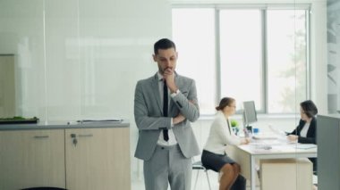 Gergin genç adam akıllı takım elbiseli iş görüşmesine modern ofis içi ve görüşmeci konuşmaya başlar yürüyüş bekliyor. Stres ve gençlik kavramı.