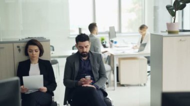 Stresli adaylar cv okuma ve kadın Yöneticisi bir adam odada görüşme smartphone kullanarak Office iş görüşmesi için bekliyor. Şirket ve personel kavramı.