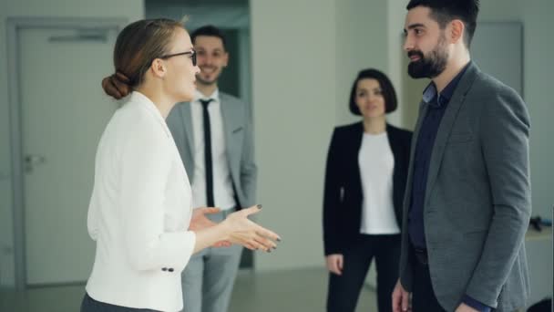 Vrolijke manager is feliciteren met de succesvolle kandidaat na sollicitatiegesprek, mensen schudden handen, praten en glimlachend, zijn werknemers handen klappen en lachen. — Stockvideo