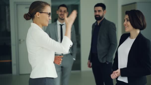 Happy young woman is getting job in company after successful interview and shaking hands with HR manager. People and smiling, laughing and clapping hands. — Stock Video