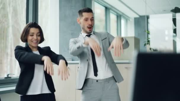 Los trabajadores de oficina descuidados se relajan en el trabajo bailando y riendo divirtiéndose juntos moviendo brazos y cuerpos. Buen humor, juventud feliz y concepto de lugar de trabajo . — Vídeos de Stock