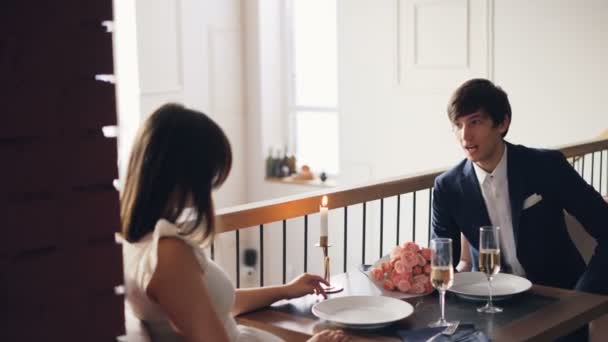 Angry young man vecht met zijn boos vriendin tijdens romantische datum in mooi restaurant. Guy is praten dan gooien bos bloemen en verlaten. — Stockvideo