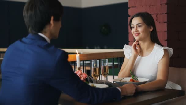 Bela jovem está feliz e surpreso depois de obter a proposta de casamento de seu namorado na data no restaurante. Ela está tomando anel, rindo e falando . — Vídeo de Stock
