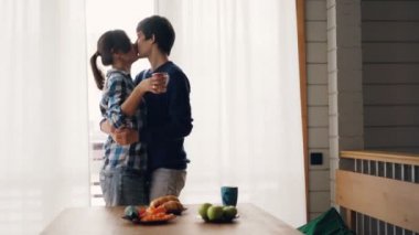 Sevimli kız ve adam mutfakta çay içiyor sonra dans ve kahvaltı duyguları ifade ve boş zaman zevk sonra öpüşme. Aşk ve aile konsepti.