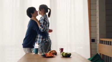 Neşeli öğrenciler kız ve adam dans ve evde müzik dinlerken Mutfak öpüşme ve sevgi ve sevgi ifade rahatlatıcı. Gençlik ve romantizm konsepti.