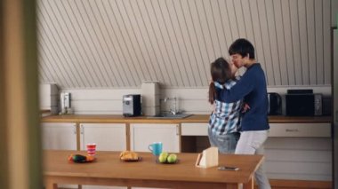 Sevgi dolu koca ve karısı neşeli genç insanlar dans ve mutfakta öpüşme evde müzik dinlerken ve evli yaşam zevk. Gençlik ve zevk konsepti.