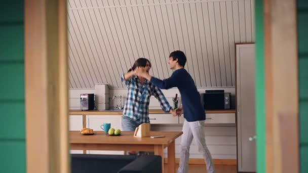 Happy young people cute girl and her joyful boyfriend are dancing in kitchen hugging and expressing feelings. Home, relationship and youth concept. — Stock Video
