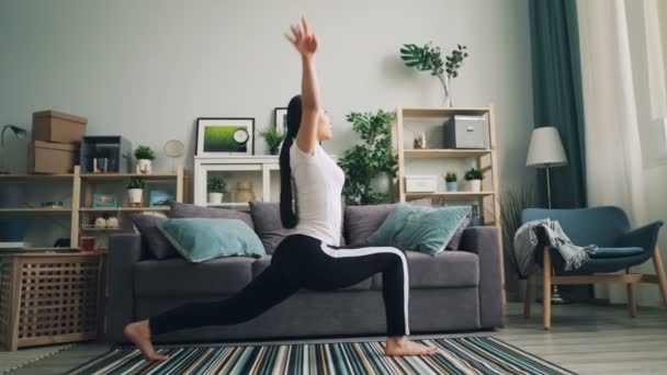 Menina asiática flexível está fazendo exercícios de alongamento em casa praticando poses de ioga sozinho melhorar sua saúde e cuidar de seu corpo. Pessoas e conceito de esportes . — Vídeo de Stock