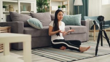 Çekici genç kız bazen önünde kamera kayıt için konuşma ve el hareketi internet online blog video konuşuyor. Kadın giyim spor giyiyor.