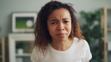 Bağırıyor, ağlıyor, mutsuz surat ve evde ayakta sonra çekip olumsuz duyguları ifade silah çırparak çileden karışık ırk kadın portresi.