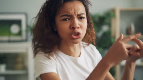 Portrait d'un adolescent afro-américain irrité en T-shirt blanc regardant la caméra, criant et battant des bras avec colère et offense. Concept jeunesse et sentiments . — Video