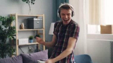 Neşeli adam dans kulaklık ve rahatlatıcı ve having fun pop müzik şarkı şarkı keyif alıyor. Millennials, becerikli alet ve yaşam tarzı kavramı.