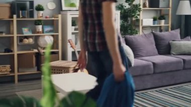 Yorgun adam ev ceket koltukta atma ve rahatlatıcı ve huzur ve barış zevk kanepede yatan geliyor. Güzel daire ve rahat mobilya görünür.