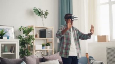 Afro-Amerikan kişi hafif dairede tek başına ayakta eller hareket sanal gerçeklik bardaklarda ilginç aktivite üzerine yoğunlaşmıştır. House, becerikli alet ve gençlik kavramı.