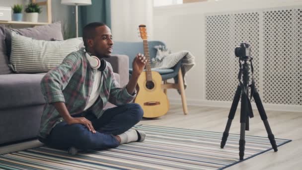 Joven blogger afroamericano está grabando video para el blog de Internet hablando y haciendo gestos mirando a la cámara y luego mostrando pulgares hacia arriba y enviando un beso aéreo a sus seguidores . — Vídeos de Stock