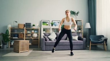 Evde egzersiz güzel kadın hafif ağız kavgası ayakta pratik odaklı yapıyor.