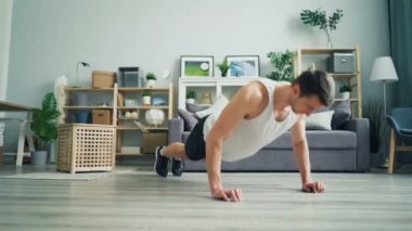 Kaslı esmer adam rahat giysiler evde çalışma pushup yapıyor